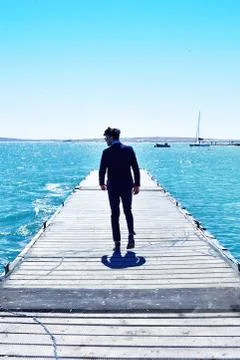 Man is Walking on the Pier Stock Photos