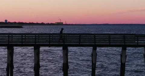 Man Walking on Pier at Sunset 4K Stock Footage 176546665