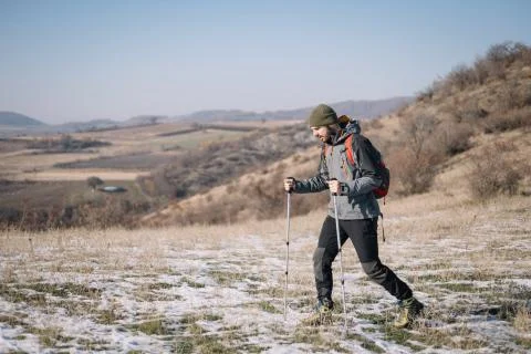 Man walking with poles on mount with fields view Stock Photos