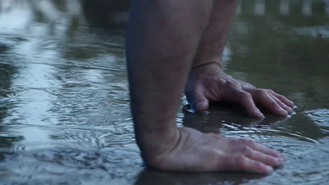 Man walking in a puddle after the rain on his hands Stock Footage 108040015