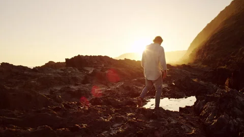 Man walking into a puddle while the sun is setting Stock Footage 279793136