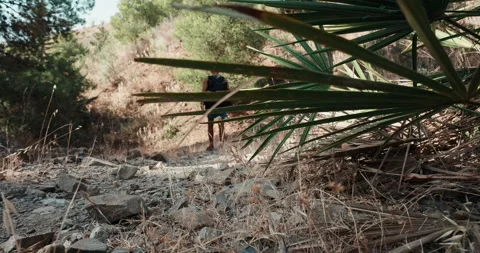 Man walking with purpose on a sunlit mountain trail, radiating self-relianc.. Stock Footage 340995401