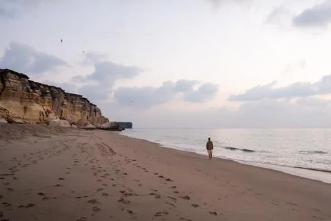 Man walking on remote oman beach exploring coastline Stock Photos