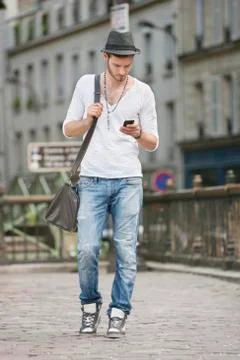 Man walking on the road and text messaging with a mobile phone, Paris, Foto stock