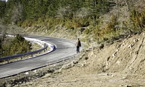 Man walking on road between mountains, exercise and nature Fotos de archivo