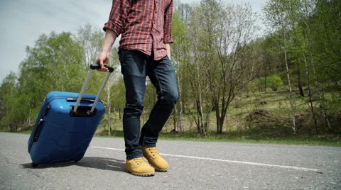 A man walking on road with suitcase	 Stock Footage 63127600