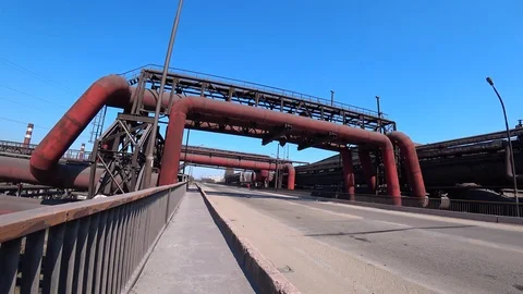 Man walking on a road through the industrial zone past huge pipes. POV Shooting. Stock Footage 105804330