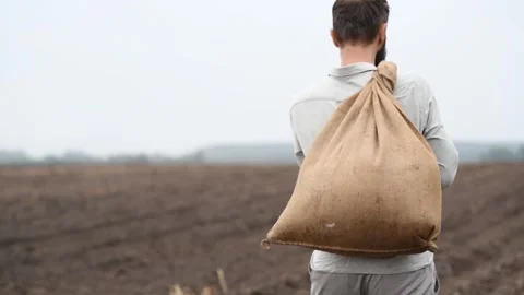 Man walking with a sack of grain slung over his shoulder 库存影片 285320468