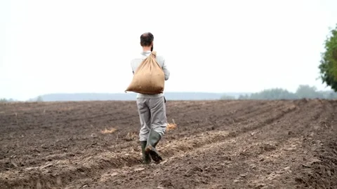 Man walking with a sack of grain slung over his shoulder Vídeo Stock 285320494
