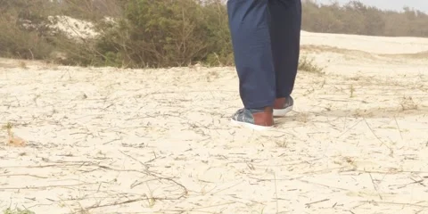 Man walking up a sand dune in at a beach in Senegal 4k slow motion 스톡 동영상 277120417