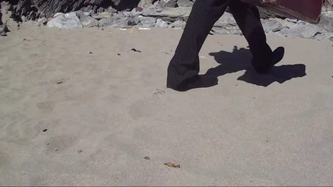 Man walking on sand with suitcase 스톡 동영상 85218353