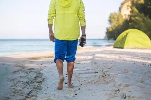 Man is walking on a sandy beach Stock Photos