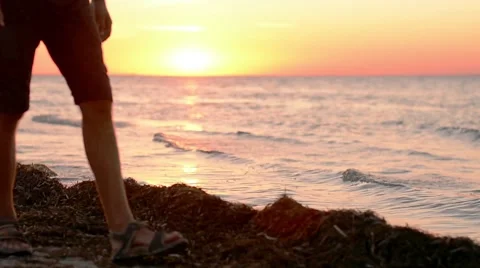 Man walking on sea beach at sunset Stock Footage 64230474