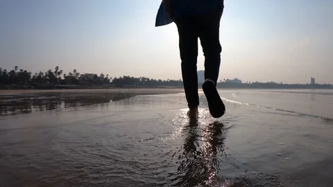 A man is walking on the sea. Madh Island beach Mumbai Stock Footage 129727062
