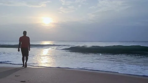 A man walking into the sea waves 스톡 동영상 234424293