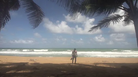 Man Walking Shirtless up Beach Slow Motion Palm Trees Either Side Stock Footage 79161383