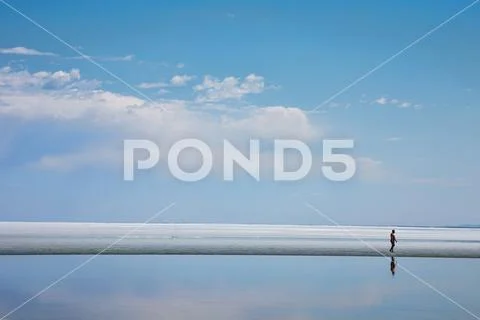 Man walking on shore of lake Stock Photos