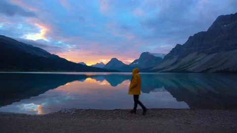 Man Walking On Shore Of Perfect Mountain Lake At Sunrise Video stock 230143796