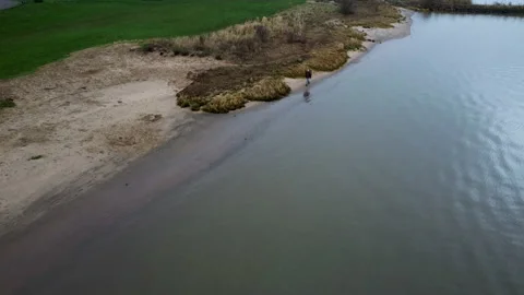 Man walking on the side off the river Lek - The Netherlands Stock Footage 169755345