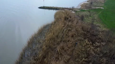 Man walking on the side off the river Lek - The Netherlands Stock Footage 169755952