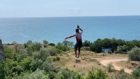A man is walking a slackline. Stock Footage 113800560