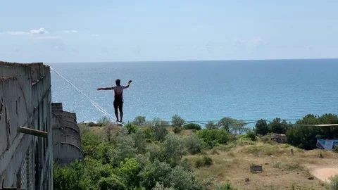 A man is walking a slackline. Stock Footage 113800631
