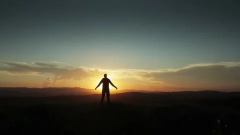 Man walking in slow motion in sunset and raising his hand up to the sky Stock Footage 135119569