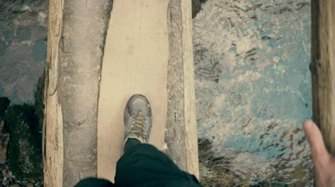 A man walking on small bridge over river in forest, point of view perspective Stock Footage 56877028