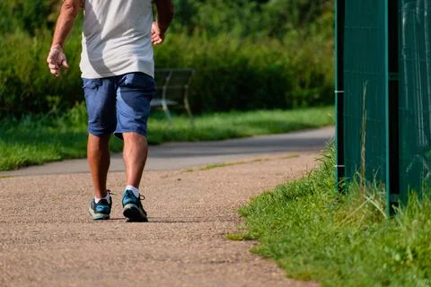 Man walking with sneakers on a path, close-up of his legs, sports activity,.. Foto stock