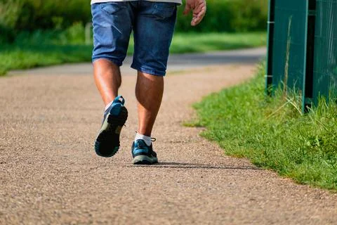 Man walking with sneakers on a path, close-up of his legs, sports activity,.. Stockfoto's