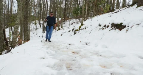 Man walking up snow covered trail Stock Footage 53860189
