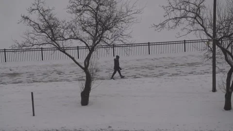 A Man Walking in the snow in slow motion Stock Footage 148516553