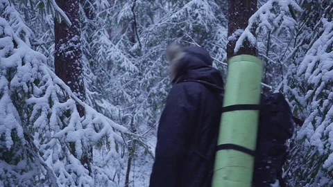 Man Walking Snow Winter Forest Traveler With Backpack. looks at the snow forest 스톡 동영상 82918510