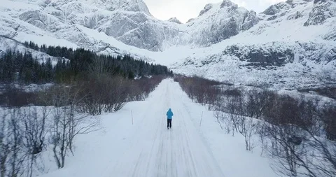 Man walking on snowy empty winter road in Scandinavia Stock Footage 108595138
