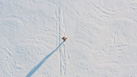Man walking on a snowy field 動画素材 117608202