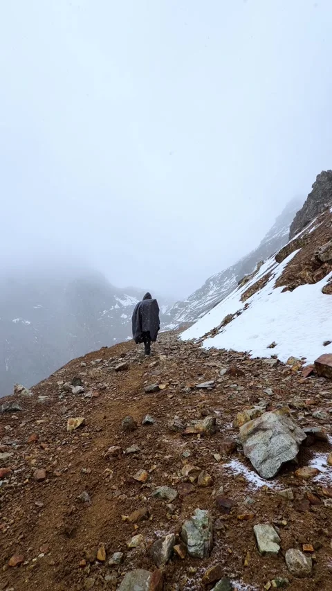 MAN WALKING ON THE SNOWY MOUNTAIN Stock Footage 327615156