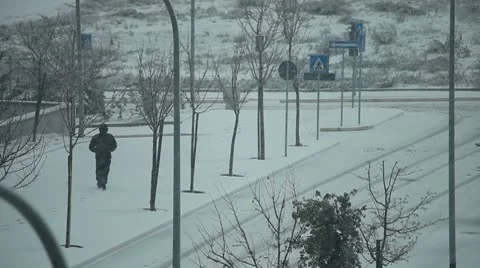 Man walking on the snowy sidewalk Stock Footage 10737363