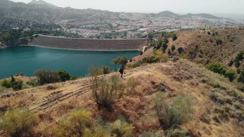 Man walking steadily along a dry, grassy ridge, radiating self-reliance and.. Stock Footage 341828728