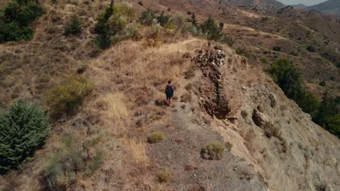 Man walking steadily along a rugged mountain ridge, embracing solitude and .. Stock Footage 341828758