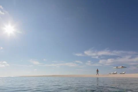 Man walking on sunny, tranquil, remote ocean  beach, Maldives Stock Photos
