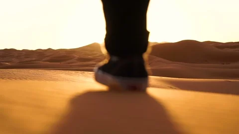 Man walking off into the sunset in desert Stock Footage