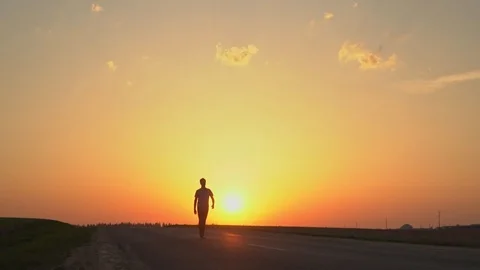 The man is walking in the sunset. Stock Footage 89383007