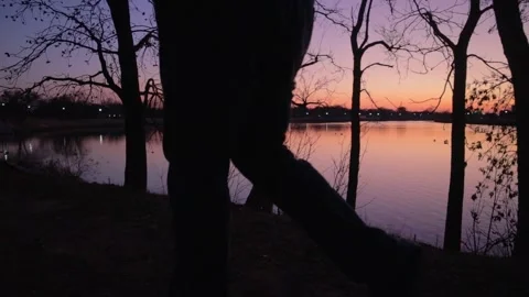 Man walking at Sunset Lake Stock Footage 272286292