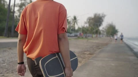 Man walking with a surf skateboard in front of the sea. Stock Footage 236407819