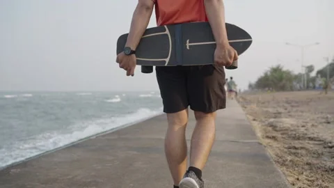 Man walking with a surf skateboard in front of the sea. Stock Footage 236407871