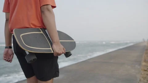 Man walking with a surf skateboard in front of the sea. Stock Footage 236407872