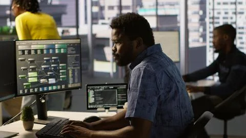 Man walking with tablet in office, fixing coding issues Stock Photos