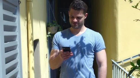 Man walking on the terrace and looking on smartphone, steadycam shot Видео 56035897