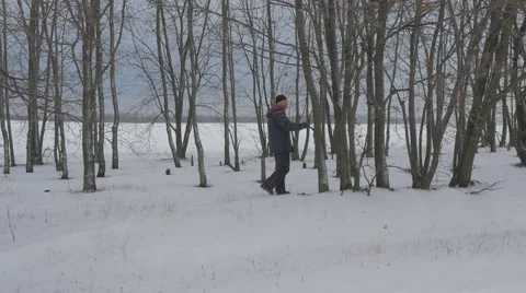 Man Walking Through Bare Branch Trees Watching Sviatogorskaya Lavra in Winter Stock Footage 58923074
