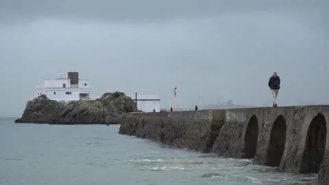 Man walking through a breakwater walk Stock Footage 151390684